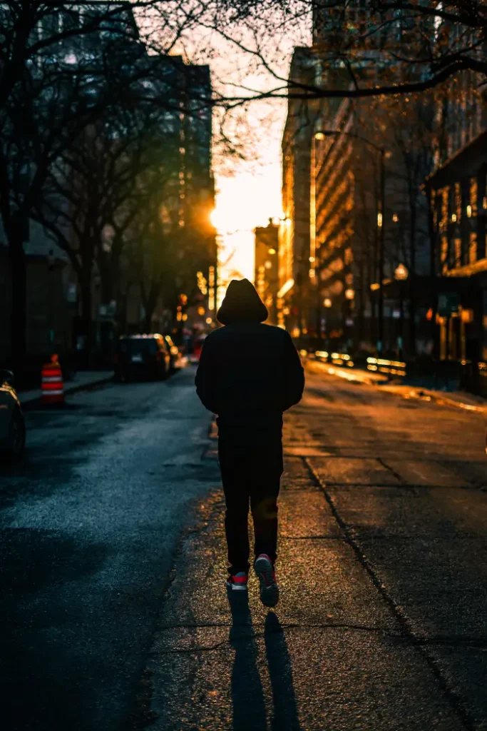 A person is walking on the road during sunset