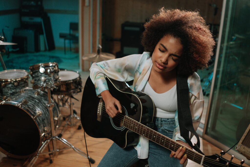 closeup of a woman playing a guitar with eyes closed