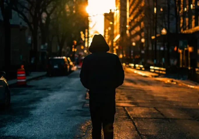 A person is walking on the road during sunset