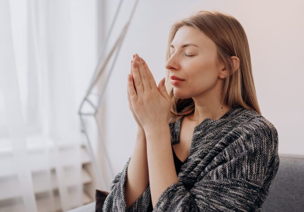 A woman meditating with hands closed